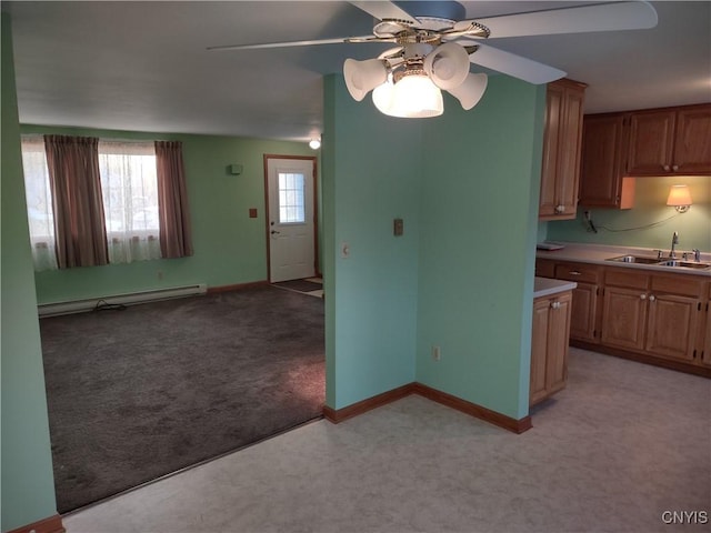 kitchen with ceiling fan, light colored carpet, a baseboard radiator, light countertops, and a sink