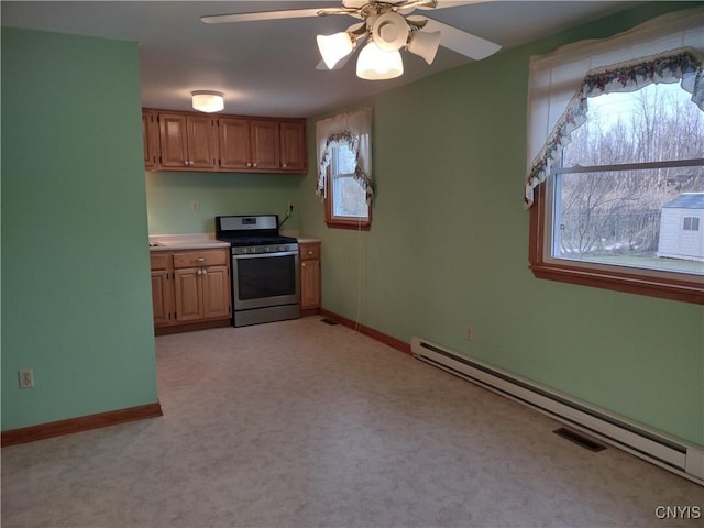 kitchen featuring a baseboard radiator, ceiling fan, light countertops, gas range, and light colored carpet