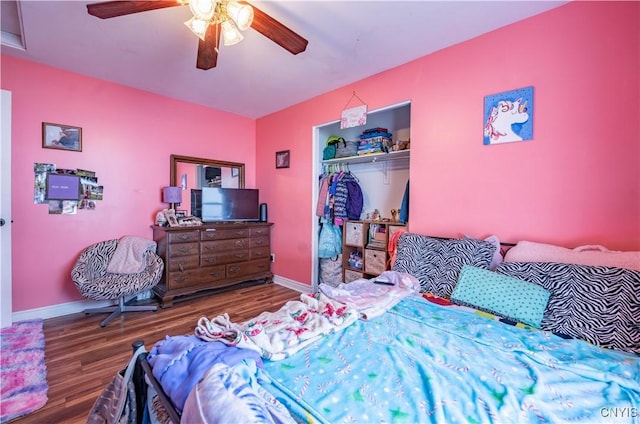 bedroom featuring a ceiling fan, wood finished floors, a closet, and baseboards