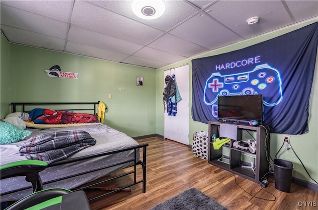 bedroom featuring wood finished floors and a paneled ceiling