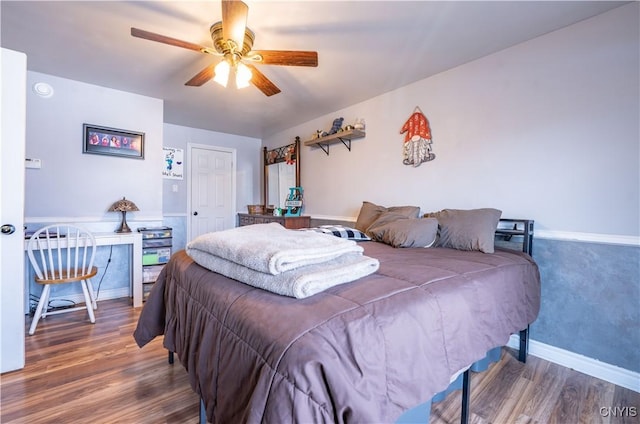 bedroom with ceiling fan, baseboards, and wood finished floors