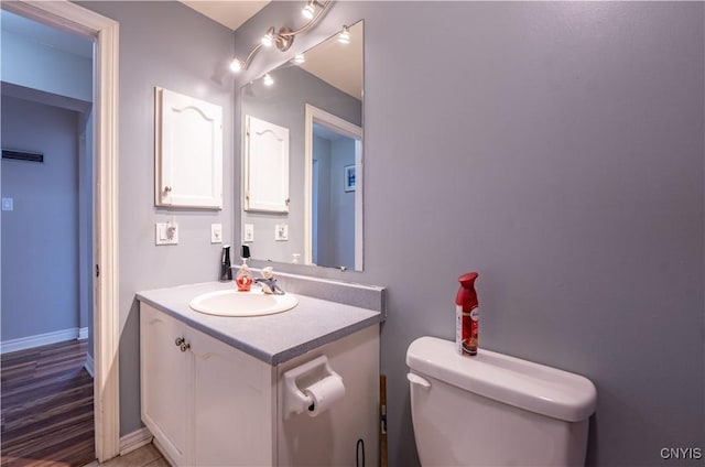 bathroom featuring vanity, toilet, and baseboards