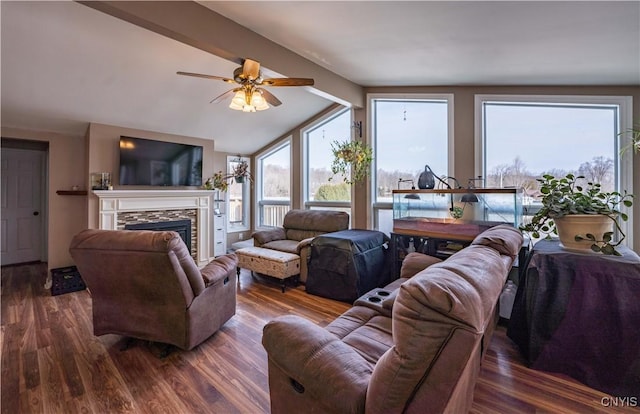 living area featuring a healthy amount of sunlight, a fireplace, ceiling fan, and wood finished floors