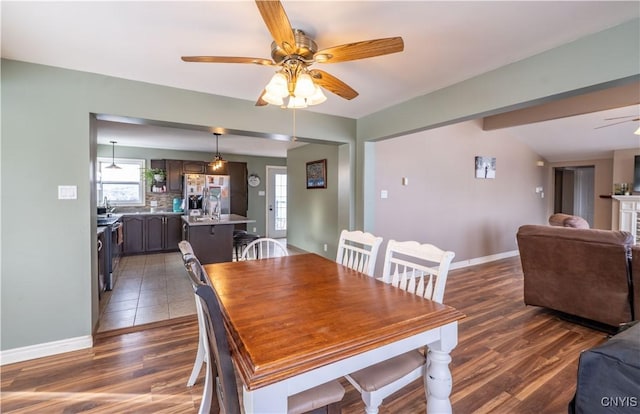 dining room featuring wood finished floors, baseboards, and ceiling fan