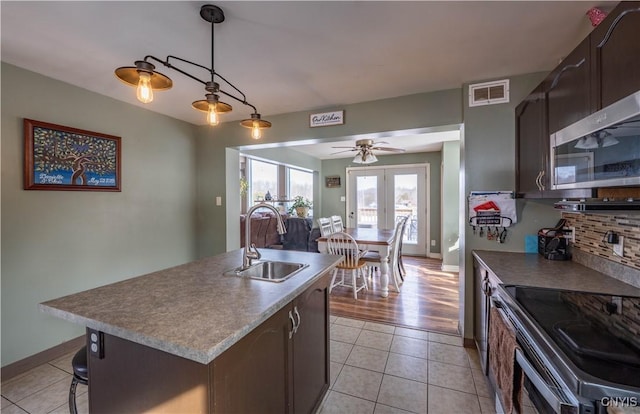 kitchen with light tile patterned floors, a ceiling fan, visible vents, a sink, and stainless steel appliances