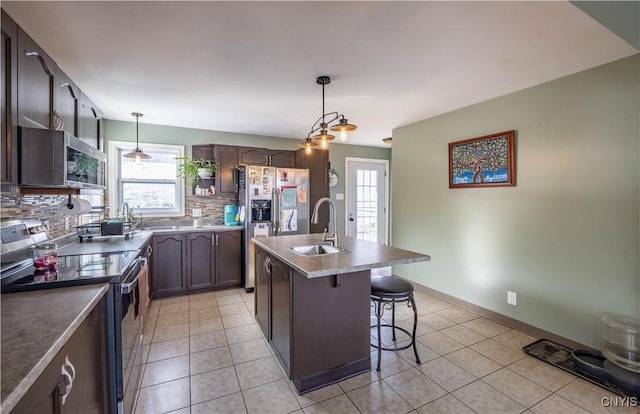 kitchen featuring backsplash, stainless steel appliances, a healthy amount of sunlight, and a sink