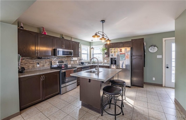 kitchen featuring a sink, decorative backsplash, appliances with stainless steel finishes, and light tile patterned floors