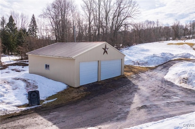 snow covered garage with a detached garage