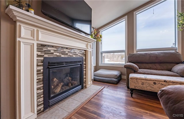 living room featuring wood finished floors and a tiled fireplace