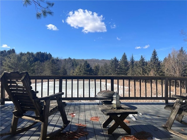 wooden terrace featuring a forest view