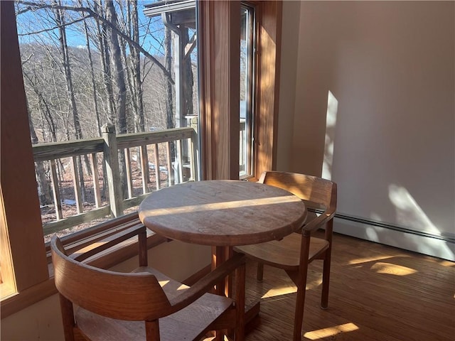 dining room featuring a baseboard heating unit and wood finished floors