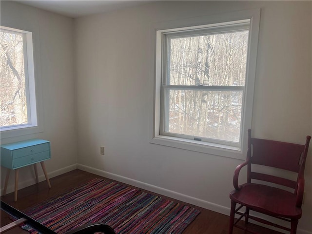 living area with baseboards and wood finished floors