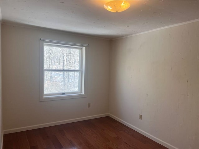 spare room featuring baseboards and wood finished floors