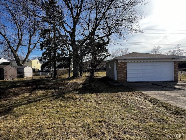 view of yard with an outbuilding, a detached garage, and fence