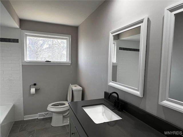 bathroom featuring visible vents, baseboards, toilet, and vanity