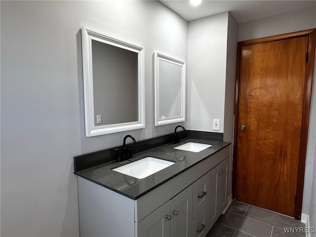 bathroom with a sink, double vanity, and tile patterned flooring