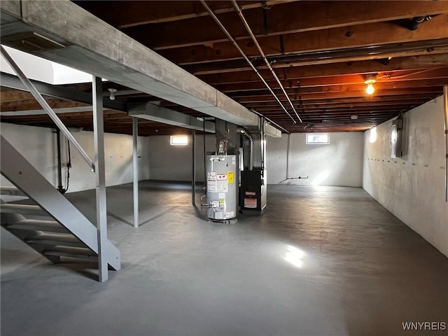 basement with heating unit, stairway, and gas water heater