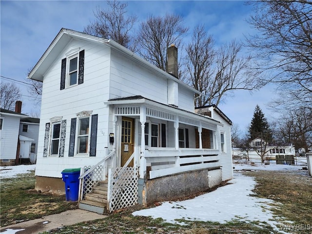 view of front facade featuring covered porch and a chimney