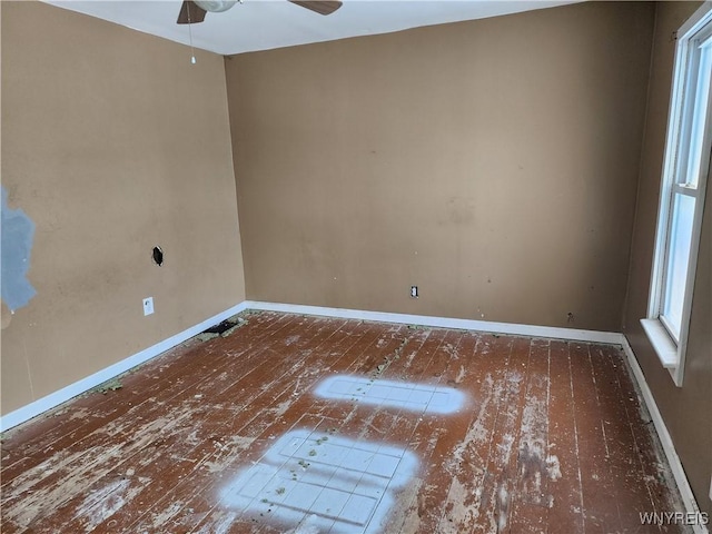 empty room featuring baseboards, wood-type flooring, and ceiling fan