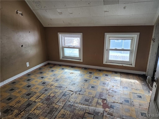 empty room with plenty of natural light and baseboards