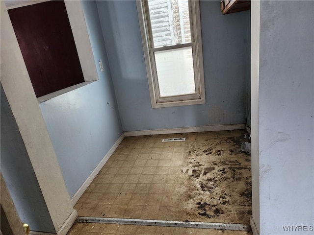 interior space with tile patterned floors, visible vents, and baseboards