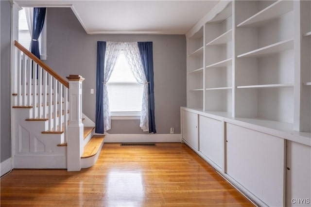 entrance foyer featuring visible vents, light wood-style floors, and stairway