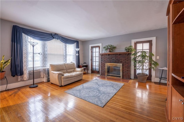 living area featuring a brick fireplace and wood finished floors