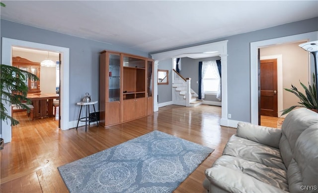 living room featuring stairs, wood finished floors, and baseboards