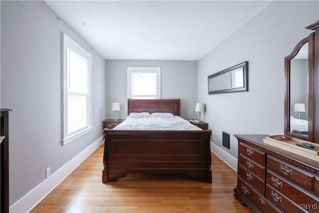 bedroom with baseboards and light wood-style flooring