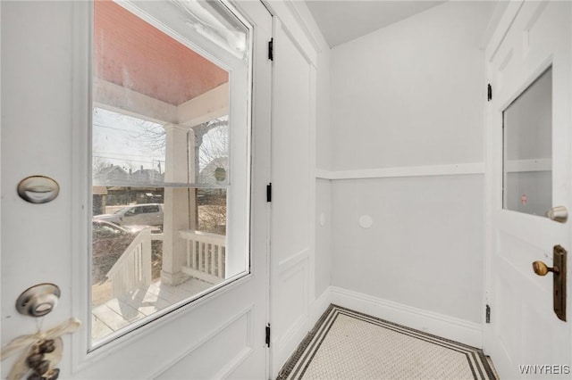 doorway to outside with baseboards