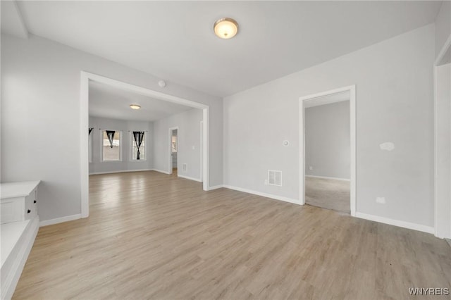 spare room with visible vents, baseboards, and light wood-style floors