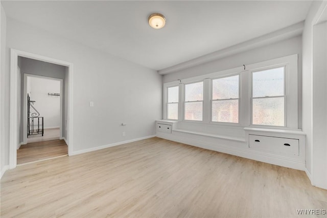 unfurnished room with baseboards and light wood-style floors