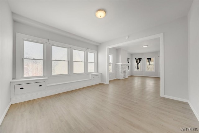 spare room featuring baseboards and light wood-style floors