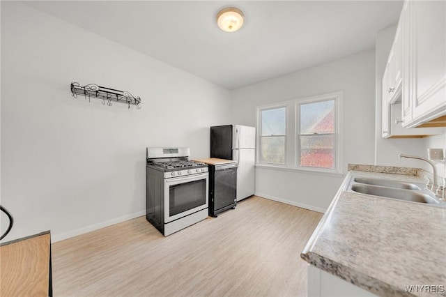 kitchen featuring white cabinetry, baseboards, stainless steel range with gas cooktop, and a sink