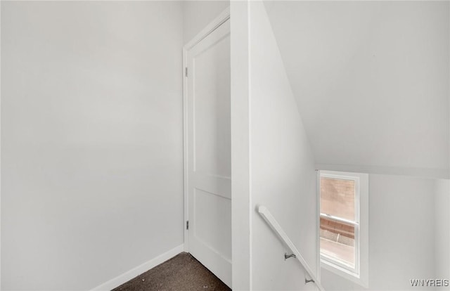 interior space with dark carpet and lofted ceiling