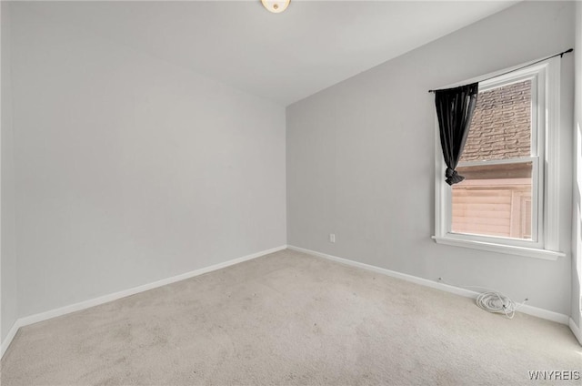 carpeted empty room featuring baseboards