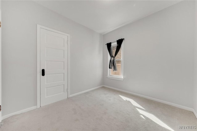 empty room featuring baseboards and carpet floors