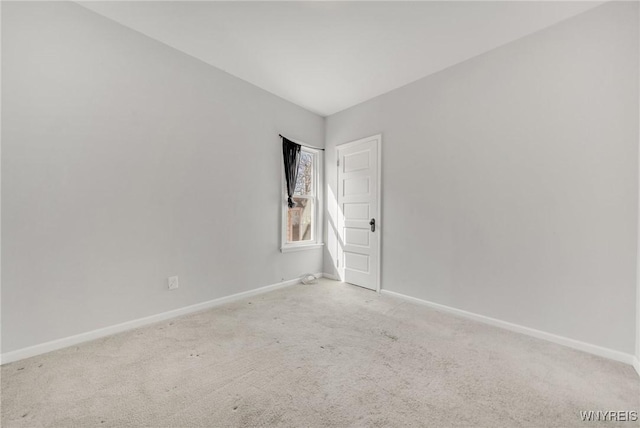 carpeted empty room featuring baseboards