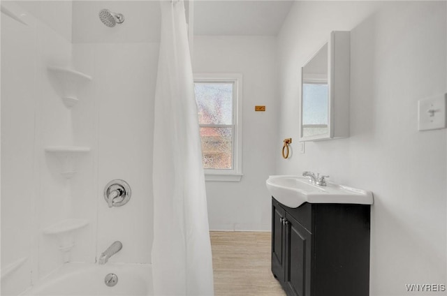 bathroom with shower / bath combo with shower curtain, wood finished floors, and vanity