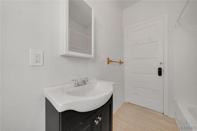 bathroom featuring a bathtub, vanity, a shower, and wood finished floors