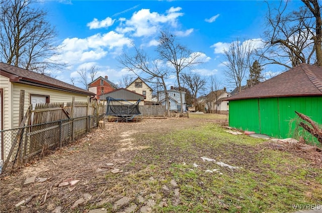 view of yard with a trampoline and a fenced backyard