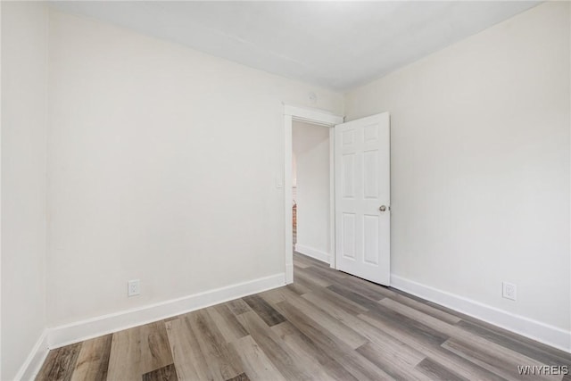 empty room with baseboards and wood finished floors