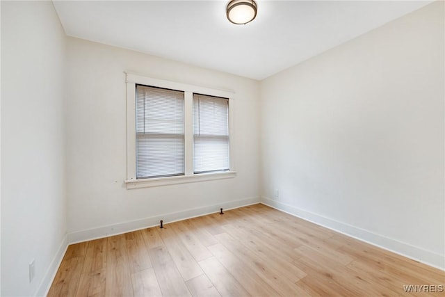 unfurnished room with baseboards and light wood-type flooring