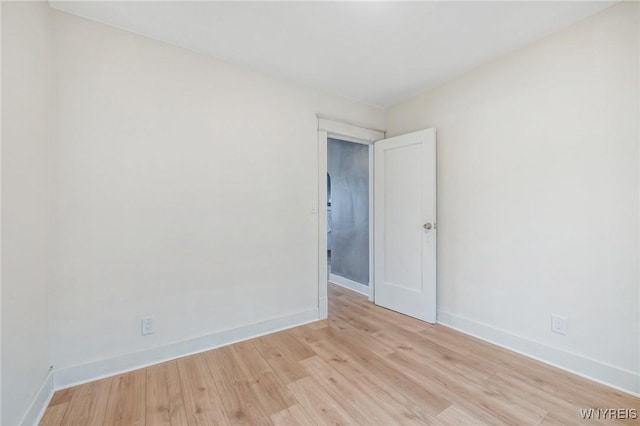 spare room with light wood-style floors and baseboards