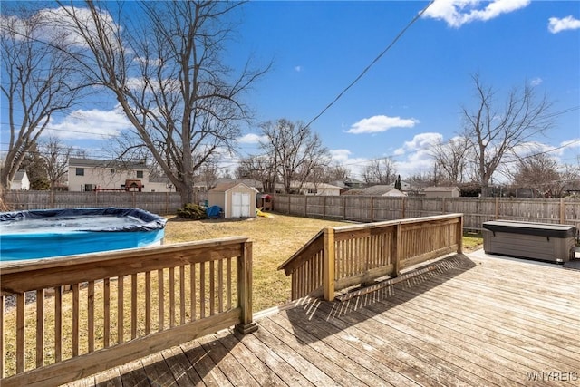 wooden deck featuring an outdoor structure, a fenced backyard, a fenced in pool, and a shed