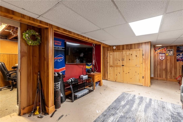 finished below grade area with wooden walls and a paneled ceiling