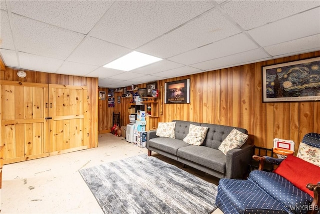 living room with wooden walls and a drop ceiling