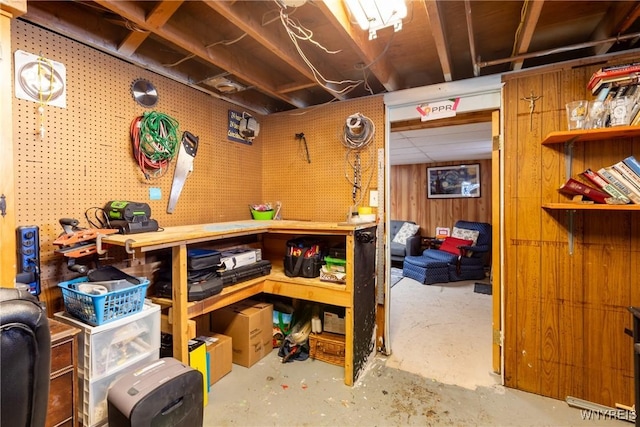 interior space with a workshop area, wood walls, and a drop ceiling