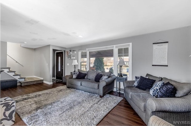 living area featuring stairs, wood finished floors, and baseboards