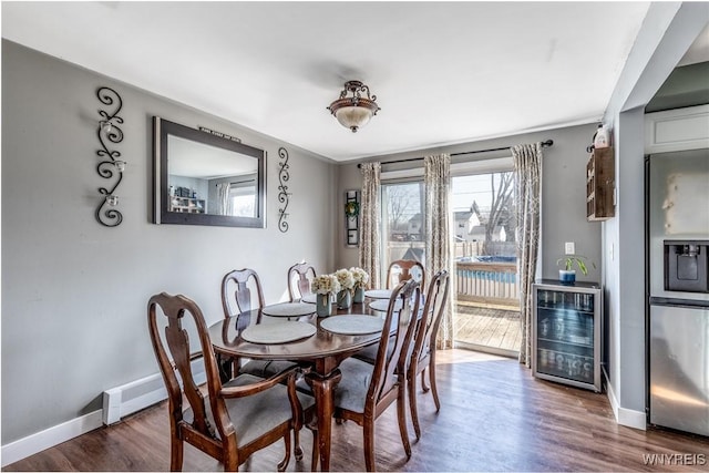 dining room featuring beverage cooler, baseboards, a baseboard radiator, dark wood-style flooring, and bar